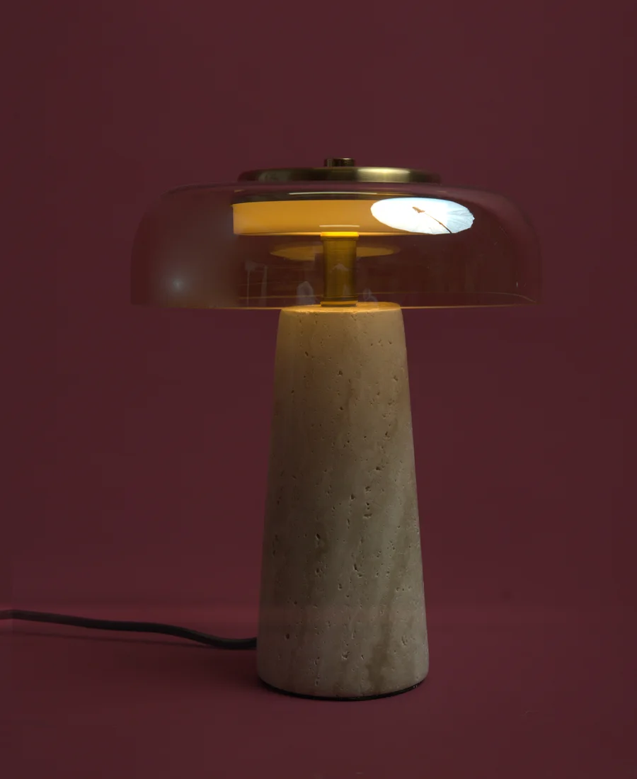 A rose glass dome lamp, lit.